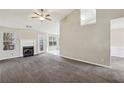 Bright living room features a fireplace, neutral walls, plush carpet, and large windows that overlook the backyard at 1559 Hillary Cove Ct, Lawrenceville, GA 30043