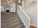 View of a carpeted staircase leading to a living room with a fireplace and ample natural light at 1559 Hillary Cove Ct, Lawrenceville, GA 30043