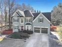 Beautiful two-story home with a manicured lawn, red fence, and an attached two-car garage at 3170 Wood Springs Sw Trce, Lilburn, GA 30047