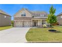 Exterior elevation view of charming home showcasing a stone and siding facade, lawn, and a two-car garage at 145 Meadow Branch Ln, Dallas, GA 30157