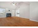 Living room boasting hardwood floors, a cozy fireplace, and abundant light from the nearby windows at 521 Carlsbad Cv, Stockbridge, GA 30281