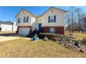 View of a two-story home with tidy lawn and landscaping features at 226 Saul Dr, Ellenwood, GA 30294