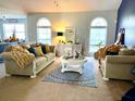Cozy living room with neutral furniture, decorative rug, and lots of natural light from large arched windows at 226 Saul Dr, Ellenwood, GA 30294