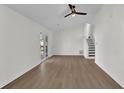 Open-concept living room with hardwood floors, a ceiling fan, and a sliding glass door to the backyard at 4391 Shiloh Hills Dr, Snellville, GA 30039