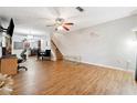 Open-concept living room featuring hardwood floors, a ceiling fan, and staircase at 1042 Wedgewood Ct, Conyers, GA 30012