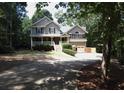 Two-story home with a covered front porch and driveway situated on a spacious lot surrounded by lush trees at 132 Hammond Dr, Canton, GA 30114