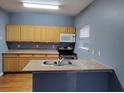 Charming kitchen with blue walls, wooden cabinetry, stainless steel microwave, oven, and granite countertops at 1470 Andrews Nw St, Atlanta, GA 30314
