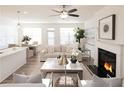 Open-concept living area boasts a fireplace, white sofa, and seamless transition to the dining area at 1597 Aiden Way # 47, Conyers, GA 30013
