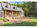 Charming home featuring a welcoming covered porch, natural stone accents, and freshly manicured landscaping at 4392 Lower Fayetteville Rd, Sharpsburg, GA 30277