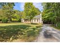 Picturesque home with a welcoming porch, classic shutters, and a long driveway nestled among mature trees at 4392 Lower Fayetteville Rd, Sharpsburg, GA 30277