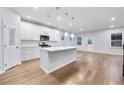 Modern kitchen with white cabinets, quartz countertops, stainless steel appliances, and island with pendant lighting at 6096 Marigold Way, Atlanta, GA 30349
