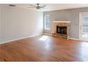 Bright and airy living room featuring hardwood floors, a brick fireplace, and a door to the outside at 1004 Hamilton Dr, Locust Grove, GA 30248