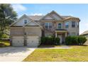 Traditional brick home with an attached two-car garage, manicured lawn, and mature shrubbery at 5253 Rosewood Pl, Fairburn, GA 30213