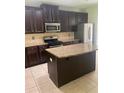 Kitchen with dark cabinets, stainless steel appliances, and a granite island at 5253 Rosewood Pl, Fairburn, GA 30213