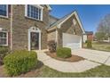 Close-up of a brick home with a two-car garage, showcasing a well-maintained lawn and trimmed shrubs at 4157 Medlock Woods Dr, Snellville, GA 30039