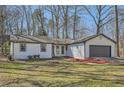 Inviting single-story home featuring a well-manicured lawn and a gray garage door at 1669 Glen Arm Dr, Lithonia, GA 30058
