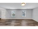 Spacious living room featuring wood-look floors and ample natural light from two windows at 5724 Antelope Trl, Atlanta, GA 30349