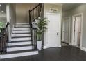 Inviting foyer showcasing a staircase with dark wood steps, a black railing, and stylish gray walls at 4569 Campenille Trce, Suwanee, GA 30024
