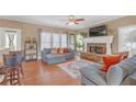 Cozy living room with a stone fireplace, hardwood floors, neutral paint colors, and plenty of natural light at 582 Braidwood Nw Dr, Acworth, GA 30101