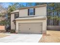Two-story home featuring a 2-car garage, and black trimmed windows, complemented by neutral siding and a well-maintained lawn at , Fairburn, GA 30213