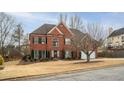 Charming red brick home with a spacious front yard and mature landscaping in a residential neighborhood at 1219 Hadaway Ct, Lawrenceville, GA 30043