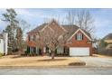 Attractive brick home with a two-car garage, a manicured lawn, and mature trees in a suburban setting at 1219 Hadaway Ct, Lawrenceville, GA 30043