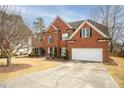 Inviting red brick home with a spacious driveway, lush lawn, and well-maintained landscaping at 1219 Hadaway Ct, Lawrenceville, GA 30043