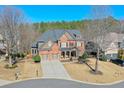 Aerial view of a beautiful two-story home with well-manicured landscaping, a two-car garage, and a cozy front porch at 1380 Magnolia Park Cir, Cumming, GA 30040