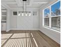 Dining room featuring an elegant light fixture, decorative wall panel, and large windows at 4024 Hosch Retreat Dr, Buford, GA 30519