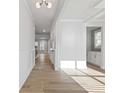 Bright hallway with light wood flooring, white trim, and modern lighting fixtures at 4024 Hosch Retreat Dr, Buford, GA 30519