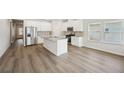 Bright kitchen boasts an island, white cabinets, stainless appliances, and ample counter space at 7758 Plymouth Dr, Fairburn, GA 30213