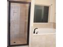 Modern bathroom showcases glass shower, soaking tub, and tiled walls with window at 651 Deer Springs Way, Loganville, GA 30052