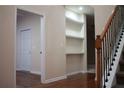 Inviting entryway showcasing hardwood floors, staircase with wrought iron spindles, and custom built-in shelving at 651 Deer Springs Way, Loganville, GA 30052