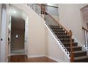 View of open staircase with carpeted steps and wrought iron spindles leading to the upper level at 651 Deer Springs Way, Loganville, GA 30052