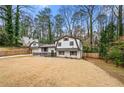 Charming home featuring a unique architectural style, complemented by a spacious front yard and mature trees at 3457 Scenic Dr, East Point, GA 30344