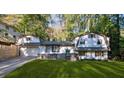Charming home featuring a unique architectural style, complemented by a well-manicured front yard and mature trees at 3457 Scenic Dr, East Point, GA 30344