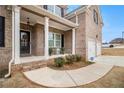 Inviting front porch with brick steps, white columns, and a charming entryway at 2031 Broadmoor Way, Fairburn, GA 30213