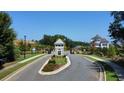 Scenic view of the community entrance, featuring manicured lawns and mature trees at 1311 Lakeside Overlook, Canton, GA 30114