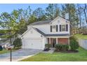 Charming two-story home featuring a white exterior, attached garage, manicured lawn, and mature trees at 455 Registry Blf, Stone Mountain, GA 30087