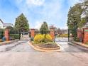 Community entrance with black iron gates, brick pillars, and manicured landscaping at 805 Vinings Forest Se Ln, Smyrna, GA 30080