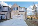 Charming two-story townhome boasts a brick facade, two-car garage and professionally landscaped yard at 552 Pennsy Aly, Mableton, GA 30126