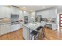 Bright kitchen featuring granite countertops, white cabinets, stainless steel appliances and wood floors at 1250 Rosette Way, Marietta, GA 30062