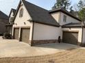 Angle view of home's facade and 3-car garage with stone accents at 4241 Summer Breeze Way, Buford, GA 30518