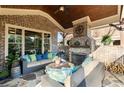 Inviting covered patio with brick fireplace, comfortable seating, and wood-paneled ceiling at 1207 Thornwell Ne Dr, Brookhaven, GA 30319