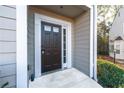 A modern dark colored front door framed by white trim and siding, with an adjacent sidelight window at 2021 Pinnacle Pointe Dr, Norcross, GA 30071