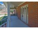 Close-up of a covered porch with brick walls, a ceiling fan, and an elegant front door at 3290 Spain Rd, Snellville, GA 30039