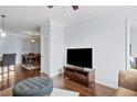 Comfortable living room with wood floors, a tufted ottoman, and views into the dining area and bedroom at 10 Perimeter Summit Ne Blvd # 4243, Brookhaven, GA 30319