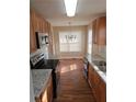 Kitchen boasts stainless steel appliances, wood cabinets, granite countertops, and a dining area at 1012 Riverclift Dr, Covington, GA 30016