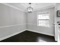 Dining room with dark wood floors, a modern chandelier, and bright natural light at 86 De Arc Nw Pl, Atlanta, GA 30327