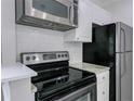 This kitchen has stainless steel appliances, white cabinets, and a tile backsplash at 86 De Arc Nw Pl, Atlanta, GA 30327
